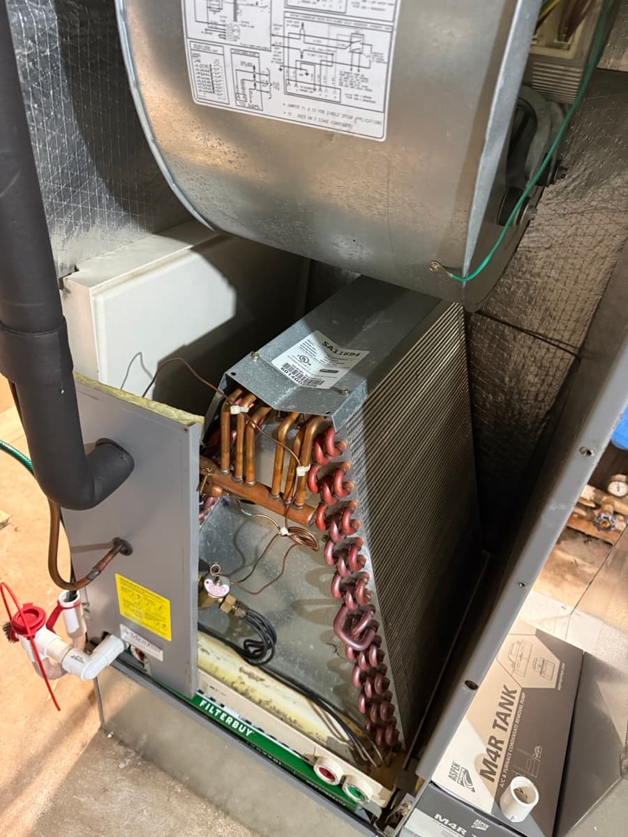 Ducted heat pump evaporator coil exposed during a deep clean