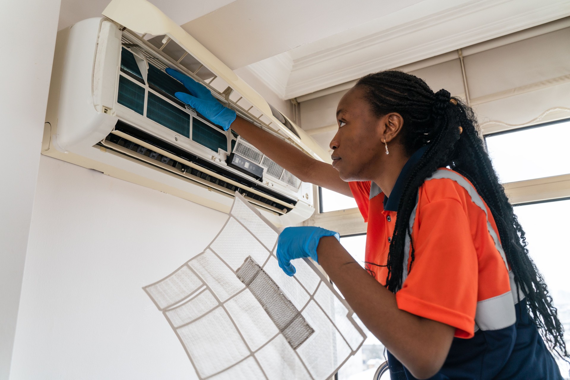 black Female technician service open air conditioner indoor for checking and repairing